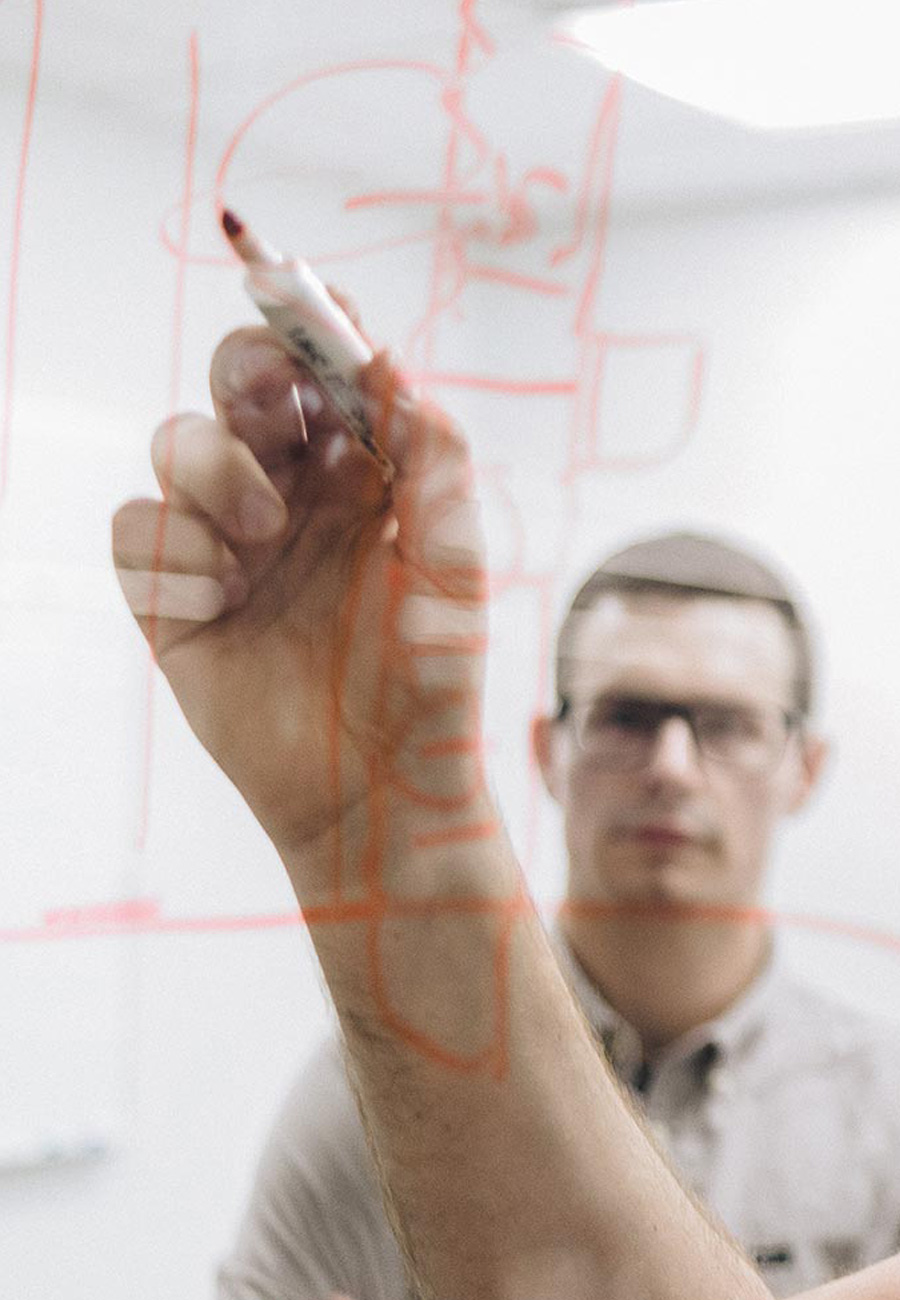 Two men collaboration on a glass whiteboard