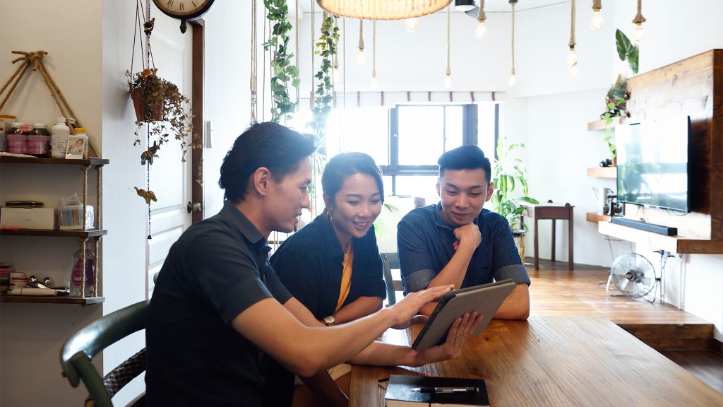 Group of people at table looking at tablet