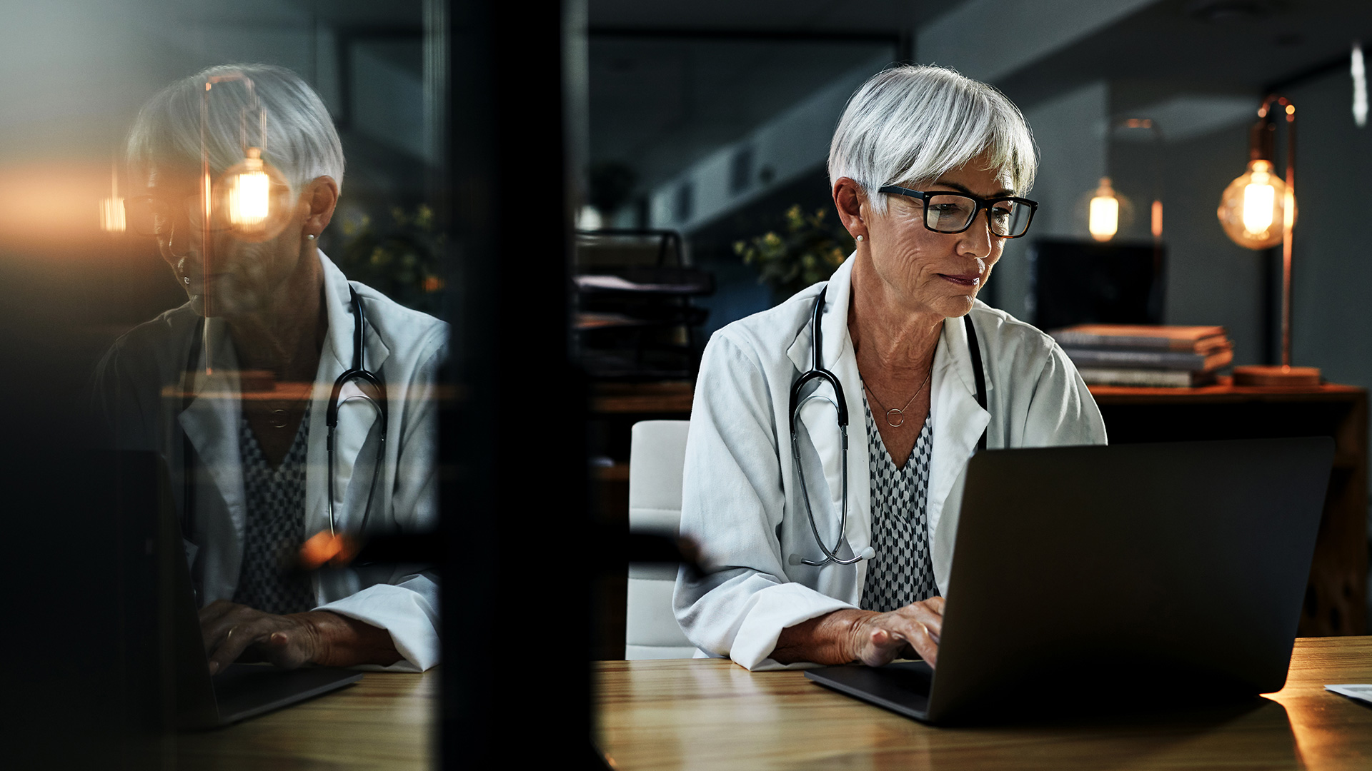 Woman doctor working at a laptop in the evening